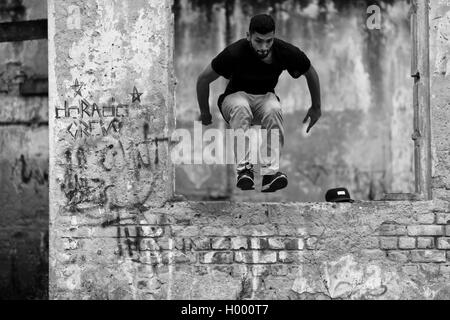 Un colombiano parkour runner esegue un salto durante una corsa libera sessione di formazione di più team di Parkour in Bogotá, Colombia. Foto Stock