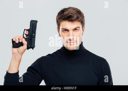 Ritratto di bel giovane in possesso di una pistola Foto Stock
