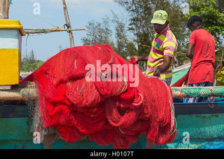 WELIGAMA, SRI LANKA - Marzo 7, 2014: pescatore preparazione rete da pesca su una barca. Il turismo e la pesca sono due attività principale in thi Foto Stock