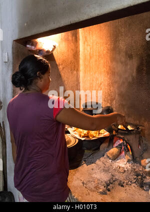 HIKKADUWA, SRI LANKA - Febbraio 23, 2014: donna locale prepara la cena. La gente del luogo prepara la cena in casa propria per i turisti Foto Stock