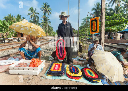 HIKKADUWA, SRI LANKA - Febbraio 23, 2014: locale i venditori di strada che vendono le cose con la ferrovia. Il mercato della domenica è una fantastica Foto Stock