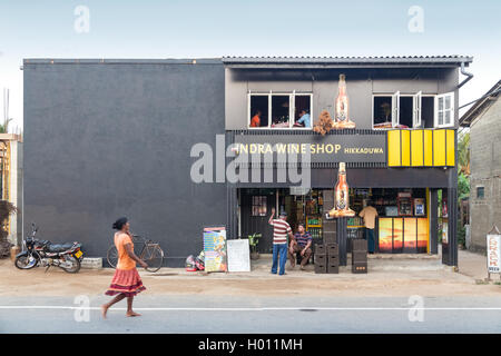 HIKKADUWA, SRI LANKA - 24 febbraio 2014: la popolazione locale di fronte all'Indra Wine Shop. Non vi è alcuna produzione di vino in Sri Lanka Foto Stock