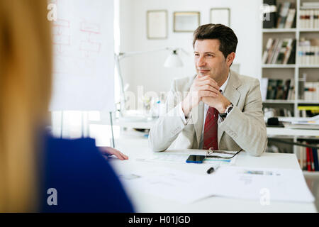 Il direttore della società seduta a tavola pensando di piani per il futuro Foto Stock