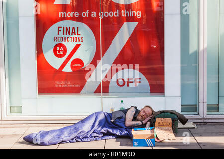 Inghilterra, London, Oxford Street, senzatetto che dorme sul marciapiede Foto Stock