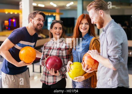 Amici divertendosi mentre bowling e speding tempo insieme Foto Stock