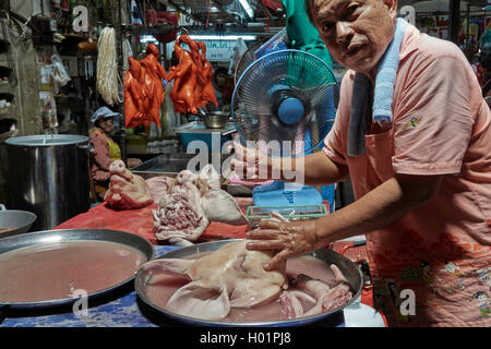 Thailandia macellaio radere la faccia e la testa di un maiale per essere più presentable per la vendita sul suo mercato stalla. Thailandia S. E. Asia Foto Stock