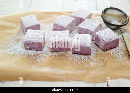 In casa di blackberry e rose marshmallows essendo tagliato e spolverato con zucchero a velo. Foto Stock