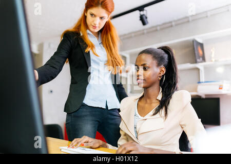 Imprenditrice di consigliare un collega in ufficio durante il lavoro Foto Stock