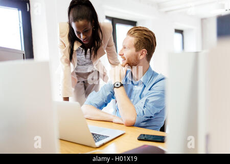 Imprenditrice di consigliare un collega in ufficio durante il lavoro Foto Stock