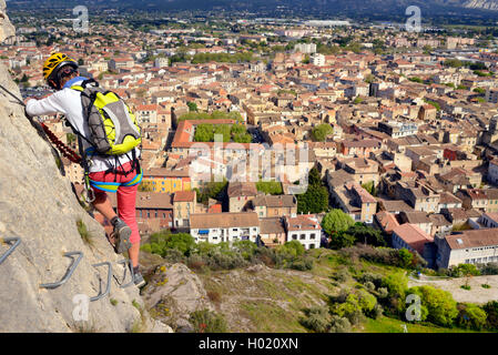 Scalatore sulla parete di roccia, città Cavaillon in background, via ferrata de CAVAILLON, Francia, Provenza, Cavaillon Foto Stock