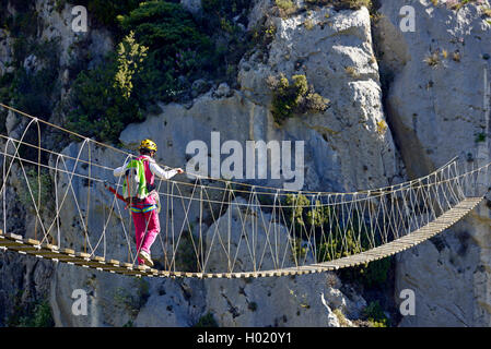 Scalatore femmina sul ponte sospeso, via ferrata Escale un Peille, Francia, Caire, Peillon Foto Stock