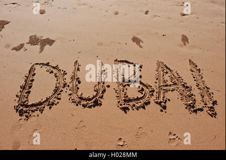 'Dubai' scritto nella sabbia sulla spiaggia Foto Stock