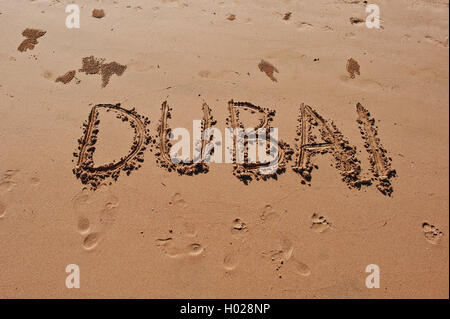 'Dubai' scritto nella sabbia sulla spiaggia Foto Stock