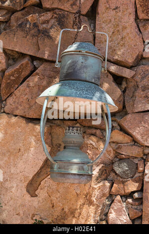 Antico Lanterna olio appesi a un muro di pietra Foto Stock