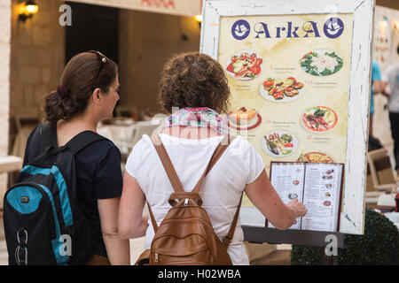 DUBROVNIK, Croazia - 28 Maggio 2014: i turisti alla ricerca di menu nella parte anteriore della terrazza del ristorante. Dubrovnik ha molti ristoranti w Foto Stock