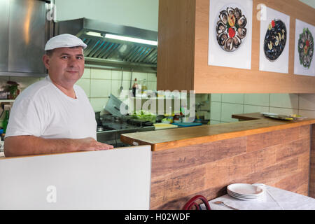 DUBROVNIK, Croazia - 28 Maggio 2014: ristorante lo chef in piedi dietro il bancone e posa per la fotocamera. Foto Stock
