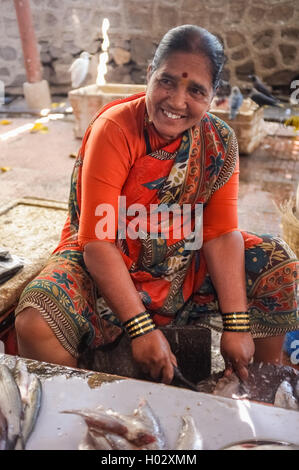 MUMBAI, India - 11 gennaio 2015: Donna pulizia del pesce su un mercato del pesce. Foto Stock