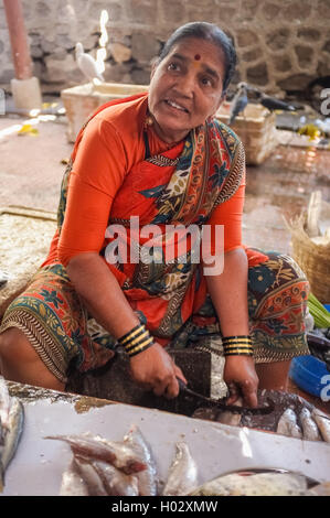 MUMBAI, India - 11 gennaio 2015: Donna pulizia del pesce su un mercato del pesce. Foto Stock