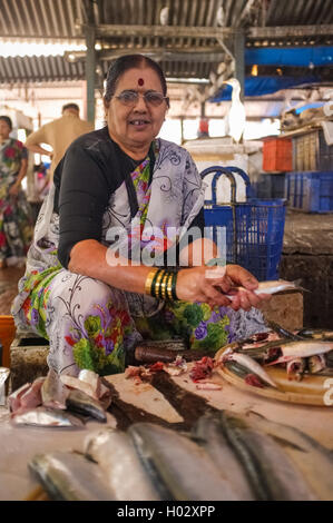 MUMBAI, India - 11 gennaio 2015: Donna pulizia del pesce in Anderi mercato del pesce. Foto Stock