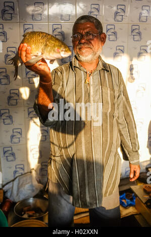 MUMBAI, India - 08 gennaio 2015: lavoratore su una pescheria accanto al Dhobi ghat che mostra un pesce in attesa per i clienti. Foto Stock