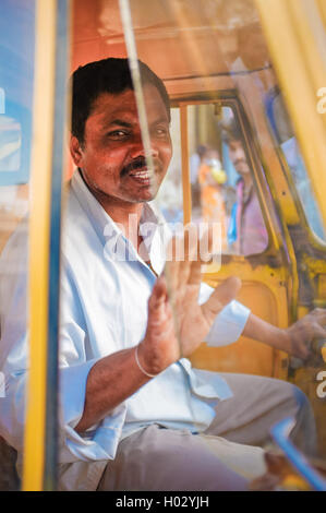 KAMALAPURAM, India - 02 febbraio 2015: consegna indiano uomo gesticulating mentre passa da una a tre ruote Foto Stock