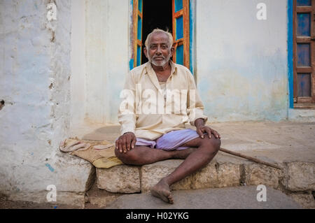 KAMALAPURAM, India - 02 febbraio 2015: Indiano anziani uomo seduto davanti a casa sua Foto Stock