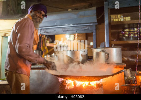 VARANASI, India - 21 febbraio 2015: venditore ambulante cuochi pasto nella pentola grande sul carbone forno a notte. Foto Stock