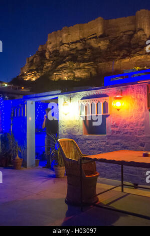 JODHPUR, India - 16 febbraio 2015: l'uomo sul telefono sulla terrazza ristorante con Forte Mehrangarh in background. Foto Stock