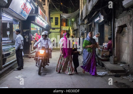 JODHPUR, India - 16 febbraio 2015: uomo sulla moto passa due donne con bambino e uomo ordinare del cibo. Foto Stock