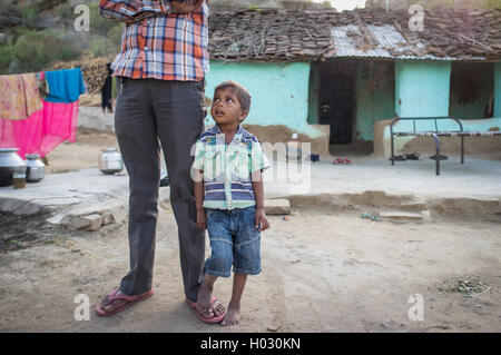 GODWAR, India - 12 febbraio 2015: Little Boy sorge accanto al padre e guarda verso di lui nel cantiere di famiglia. Il padre non in vista. Foto Stock