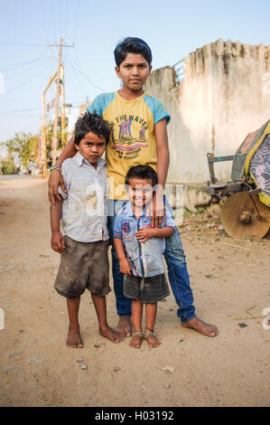 HAMPI, India - 31 gennaio 2015: tre giovani ragazzi indiani in piedi in strada polverosa Foto Stock