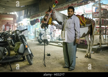 JODHPUR, India - 07 febbraio 2015: allenatore di cavalli in piedi in strada detiene il cavallo decorata in stile tradizionale indiano prima di tak Foto Stock