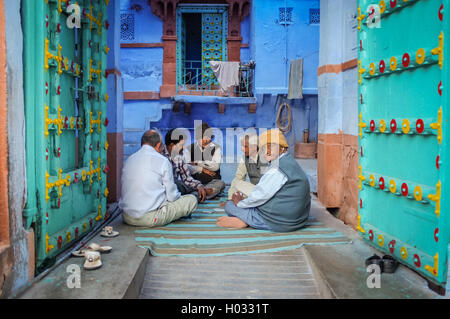 JODHPUR, India - 07 febbraio 2015: cinque uomini anziani seduti sul terreno in gateway del cortile e carte da gioco nella vecchia parte di J Foto Stock