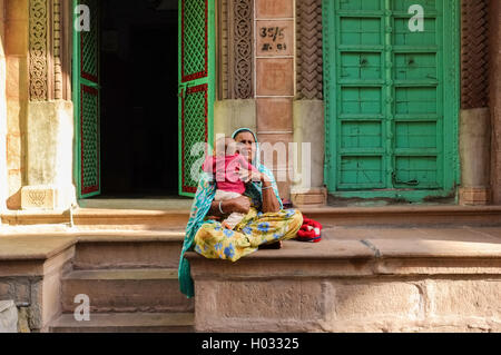 JODHPUR, India - 07 febbraio 2015: Nonna di sari colorati seduti di fronte home azienda nipote. Foto Stock