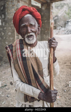 Regione GODWAR, India - 13 febbraio 2015: la cieca Rabari tribesman detiene il bastone nel cortile. Post-elaborati con grano, texture e Foto Stock