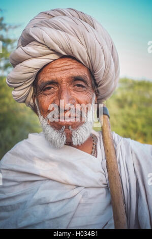 Regione GODWAR, India - 14 febbraio 2015: Anziani Rabari tribesman con turbante bianco e coperta intorno alle spalle e ax. Il pos Foto Stock