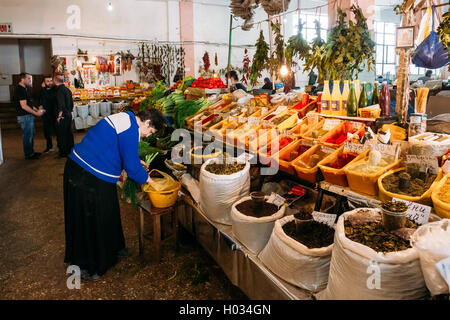 Batumi, Georgia - 28 Maggio 2016: vista laterale di anziani donna georgiana concessionario ordinamento di Vegetazione fresca vicino al contatore di abbondanti di F Foto Stock