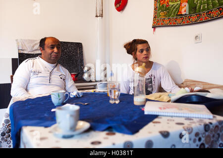 Zagabria, Croazia - 12 novembre 2013: famiglia Roma seduti al tavolo della cucina a casa loro. Foto Stock