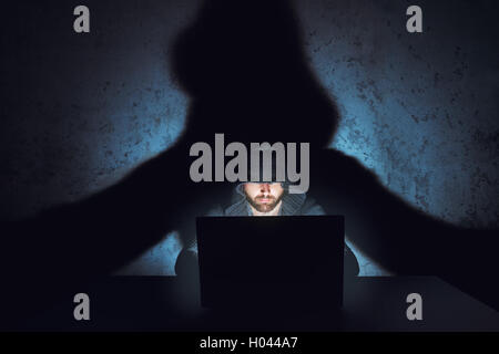 L'uomo hacker che lavora nel buio stanza vuota Foto Stock