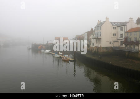 Barche ormeggiate nel porto di Whitby su un nebbioso giorno Foto Stock