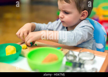 Little Boy di essere creativi con la plastilina Foto Stock