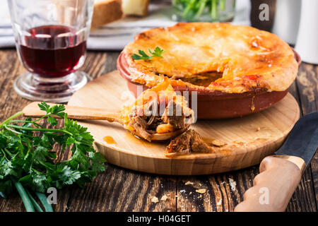 Succosa carne pot la torta in un forno per ceramica pentola, stufato di manzo con torta di pasta sfoglia Foto Stock