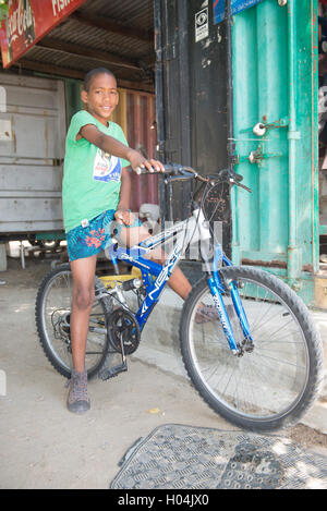 Ragazzo africano seduti tranquillamente sulla sua bicicletta, Cape Town, Sud Africa Foto Stock