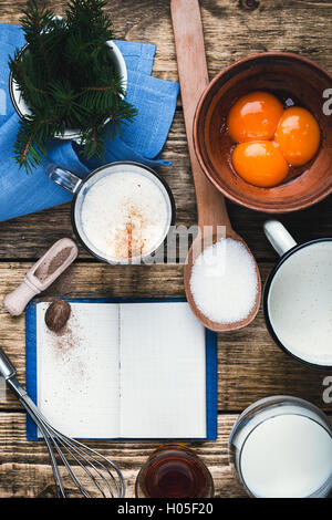 Zabaione ingredienti su tavola in legno rustico con spazio copia vista dal di sopra. Uovo punzone di latte a crudo con i tuorli, il latte, la crema di latte Foto Stock