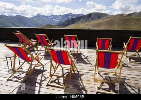 Vuoto colorate sedie a sdraio sulla terrazza con Alpi Italiane vista montagne Foto Stock