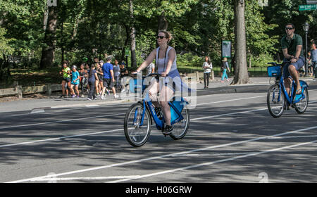 Un uomo e una donna sono citibikes equitazione nel Parco Centrale. Foto Stock