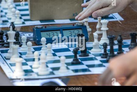 Un gioco di scacchi è in corso un giocatore sta completando una mossa. Foto Stock