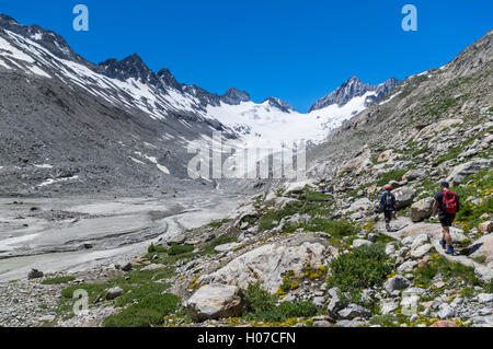 Due escursionisti maschio Oberaargletscher approccio, un ghiacciaio delle Alpi svizzere nella regione di Grimsel del Berner Oberland, Svizzera. Foto Stock