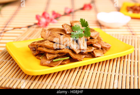 Fritte tagliate a fette di carne di anatra su piastra di colore giallo sul tavolo nel ristorante Foto Stock