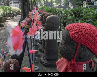 Jizo statue, con offerte di giocattoli, il tempio di Zojo-ji, Minato, Tokyo, Giappone Foto Stock